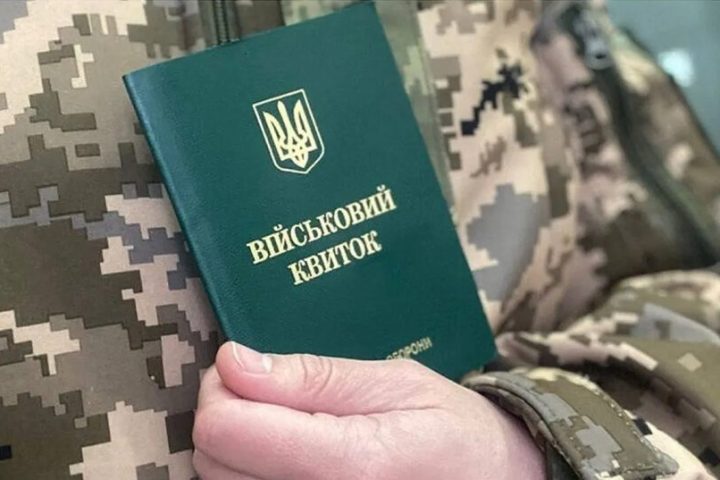 Чоловік тримає військовий квиток